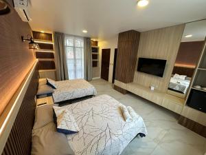 een hotelkamer met twee bedden en een flatscreen-tv bij Paraje La Huerta in Oaxaca City