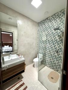 een badkamer met een wastafel, een toilet en een douche bij Paraje La Huerta in Oaxaca City