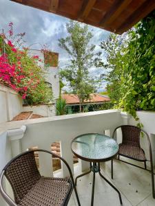 een terras met twee stoelen en een tafel op een balkon bij Paraje La Huerta in Oaxaca City +21 foto's