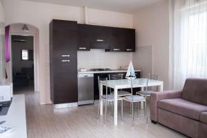 a kitchen and living room with a table and a couch at Casa Vacanza TDL in Torre del Lago Puccini