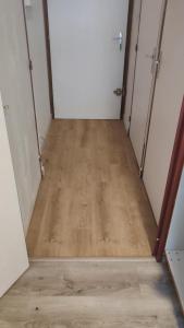 a hallway with two doors and a wooden floor at Charmant appartement de montagne avec balcon in Mijoux
