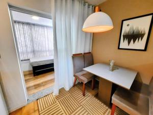 ein kleiner Raum mit einem Tisch und einem Fenster in der Unterkunft Apartamento Centro de Capão da Canoa in Capão da Canoa