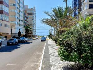 eine Straße mit am Straßenrand geparkten Autos in der Unterkunft Apartamento Centro de Capão da Canoa in Capão da Canoa