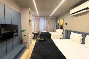 a hotel room with two beds and a television at Setai Yatch - Praia in João Pessoa