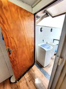 ein Badezimmer mit Toilette und Holztür in der Unterkunft Apartamento Centro de Capão da Canoa in Capão da Canoa + 15 Fotos