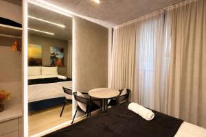 a room with a bed and a table and a bedroom at Setai Yatch - Praia in João Pessoa