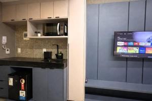 a kitchen with a sink and a tv on a wall at Setai Yatch - Praia in João Pessoa