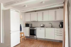 uma cozinha com armários brancos e um fogão com forno em SKA694-Hoeganaes-Hustoftavaegen-95 em Höganäs mais 21 fotografias