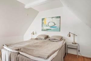 um quarto com uma cama grande em um quarto branco em SKA694-Hoeganaes-Hustoftavaegen-95 em Höganäs
