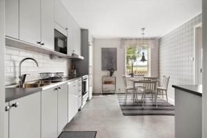 a kitchen with white cabinets and a table in it at OGO781-Mjoelby-Norrby-Naesloesegard-1 in Mjölby