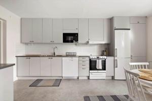a kitchen with white cabinets and a white refrigerator at OGO781-Mjoelby-Norrby-Naesloesegard-1 in Mjölby +24 photos