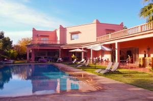 a house with a swimming pool in front of a house at Villa Essalah & Spa Marrakech in Marrakech