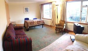 a living room with a couch and a table at House for Groups & Contractors Kilmarnock in Kilmarnock