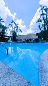 ein großer blauer Pool mit einem Haus im Hintergrund in der Unterkunft Hotel Itatiaia das Thermas in Caldas Novas