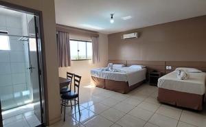 ein Hotelzimmer mit zwei Betten und einem Badezimmer in der Unterkunft Hotel Itatiaia das Thermas in Caldas Novas