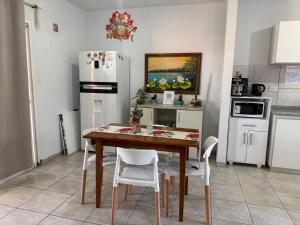 波萨达斯Casa Yvy Guazú的厨房配有木桌和白色家电 更多4张照片