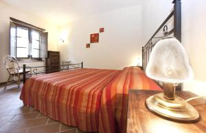 a bedroom with a bed and a table with a lamp at Agriturismo Casa Olinto in Sarteano