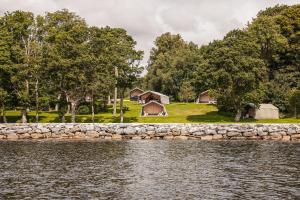 a cabin by the water with a stone wall at Dromquinna Manor in Dunkerron Islands