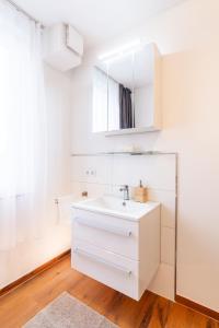 Weisser Ochsen - smart living by corents في شفايبيش غموند: حمام أبيض مع حوض ومرآة +29 صورة