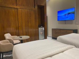 una camera d'albergo con due letti e una TV a parete di Jyazelle Resort a Al Ghuţghuţ