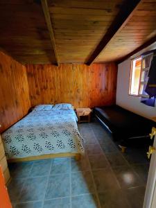 ein Schlafzimmer mit einem Bett und einer Couch in einem Zimmer in der Unterkunft El Rinconcito in El Bolsón