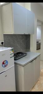 شقق رحابة المكان للشقق المفروشه في الخرج: مطبخ بخزائن بيضاء وفرن موقد