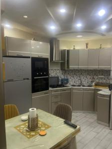 eine Küche mit weißen Schränken und einem Tisch mit Stühlen in der Unterkunft Lotiss in Monastir