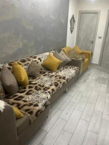 ein Wohnzimmer mit einer Couch mit Leopardenkissen in der Unterkunft Lotiss in Monastir
