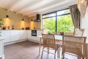 una cocina con mesa y sillas y una ventana en Vakantiepark De Kremmer, en Gasselte 4 fotos más