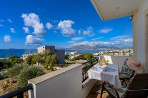 ein Balkon mit Tisch und Meerblick in der Unterkunft Family Home, with Sea & Mountain view in Kalamaki