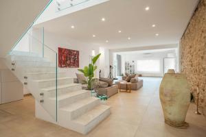 eine weiße Treppe in einem Wohnzimmer mit einer Glaswand in der Unterkunft Historic Villa Overlooking Scopello Sea Stacks in Castellammare del Golfo