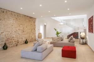 ein Wohnzimmer mit 2 Sofas und einer Ziegelwand in der Unterkunft Historic Villa Overlooking Scopello Sea Stacks in Castellammare del Golfo
