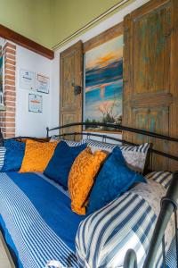 Schlafzimmer mit einem Bett mit blauen und orangefarbenen Kissen in der Unterkunft Apartments Peric in Igrane