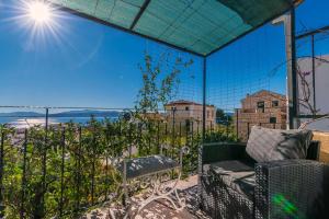 ein Balkon mit Stuhl und Blick auf das Meer in der Unterkunft Apartments Peric in Igrane