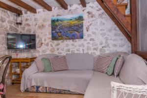 een woonkamer met een bank en een tv bij House Vedrana in Igrane