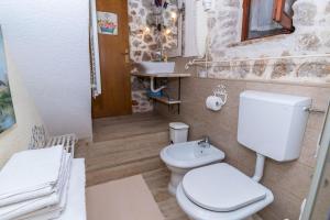 een badkamer met een wit toilet en een wastafel bij House Vedrana in Igrane +14 foto's