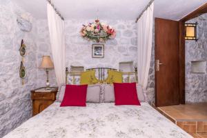 een slaapkamer met een groot bed met rode kussens bij House Vedrana in Igrane