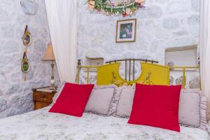 a bedroom with a bed with red and white pillows at House Vedrana in Igrane