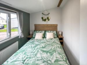 een slaapkamer met een bed met een groen dekbed bij D & A Southview Getaway in Toynton All Saints