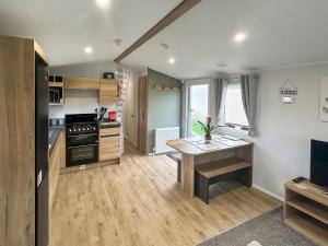 een keuken met een tafel en een fornuis bovenste oven bij D & A Southview Getaway in Toynton All Saints