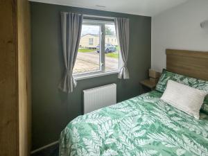 een slaapkamer met een groen bed en een raam bij D & A Southview Getaway in Toynton All Saints +7 foto's