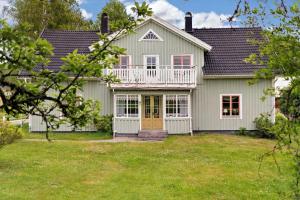uma casa branca com uma varanda e um quintal em KRO084-Linneryd-Skogsholm-Skogsryd em Sandvik