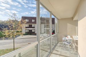 a balcony with glass doors and a table and chairs at Aqua apartment in Druskininkai