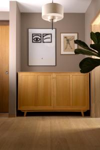 ein Wohnzimmer mit einem Holzschrank und einer Topfpflanze in der Unterkunft Modern Japandi retreat in Stockholm in Stockholm