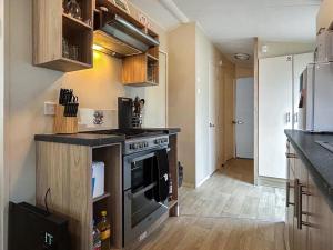 een keuken met een fornuis en een koelkast bij Ali B's Craig Tara in Ayr