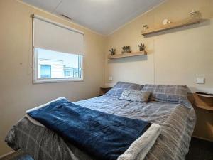 een slaapkamer met een bed met een blauwe deken erop bij Ali B's Craig Tara in Ayr