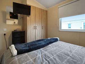 een slaapkamer met een bed waarop een groot blauw kussen ligt bij Ali B's Craig Tara in Ayr +7 foto's