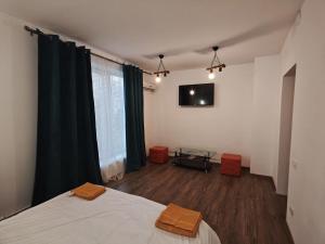 a bedroom with a bed and a table and a television at Studio ultracentral stefan cel mare in Craiova