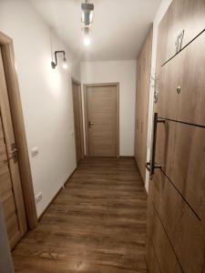 een hal met houten vloeren en een deur bij Studio ultracentral stefan cel mare in Craiova