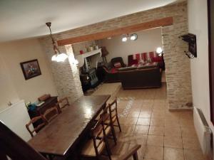 a dining room and living room with a table and chairs at Gîte Chez Albertine in Spoy